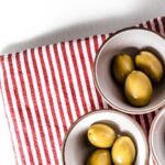 green round fruits on stainless steel bowl