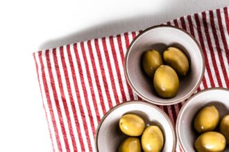 green round fruits on stainless steel bowl