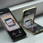 Two cell phones sitting next to each other on a window sill