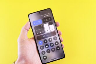 Hand holding smartphone with control panel on screen