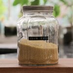 a jar filled with sand sitting on top of a wooden table