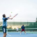 four men playing double tennis during daytime