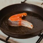 a fish is being cooked in a frying pan