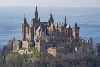 a castle on a hill with Hohenzollern Castle in the background