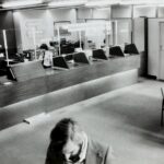 grayscale photo of man holding paper