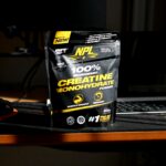 A bag of creatinne on a desk next to a keyboard