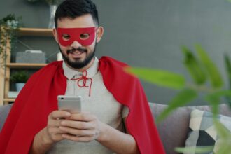 Man in superhero costume using smartphone on his smartphone