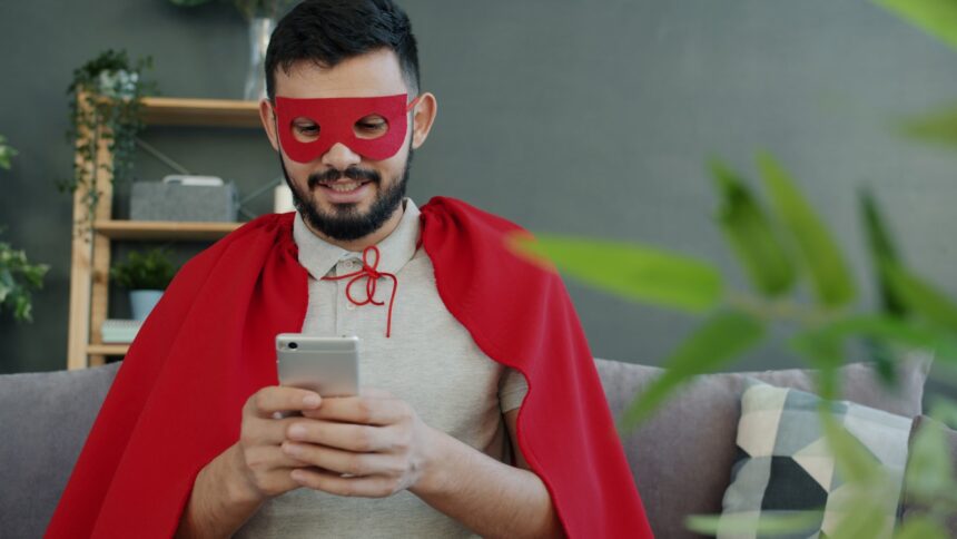 Man in superhero costume using smartphone on his smartphone