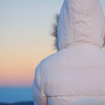 a person in a white jacket looking at the sky